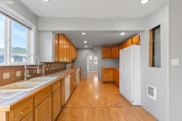 kitchen with white appliances, light hardwood / wood-style flooring, sink, and tile counters