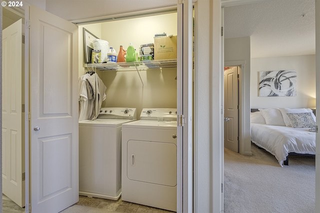 clothes washing area featuring independent washer and dryer, laundry area, and light carpet