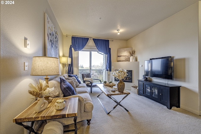 carpeted living room featuring a textured ceiling and a fireplace