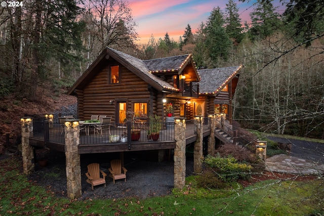 back house at dusk with a wooden deck