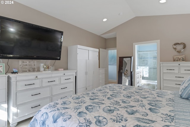 bedroom featuring light colored carpet, a closet, lofted ceiling, and ensuite bathroom