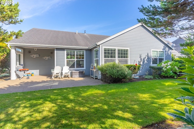 back of house with a lawn and a patio