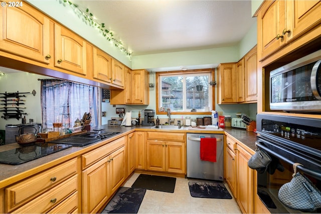 kitchen featuring black appliances, light tile patterned flooring, sink, and rail lighting