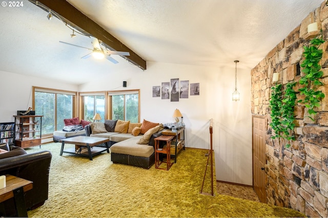 carpeted living room featuring lofted ceiling with beams, ceiling fan, and a textured ceiling