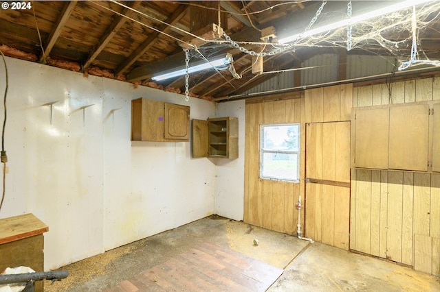 basement featuring wooden walls