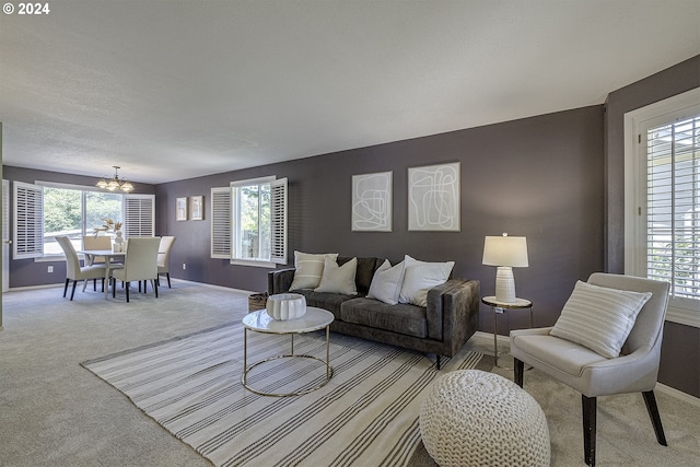 living room with carpet flooring, a chandelier, and plenty of natural light