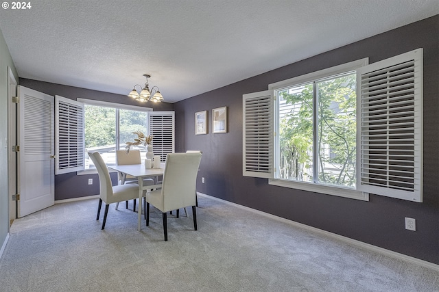 carpeted dining area with a textured ceiling and a chandelier