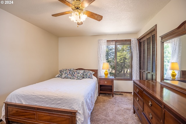 bedroom featuring multiple windows, ceiling fan, light carpet, and a textured ceiling