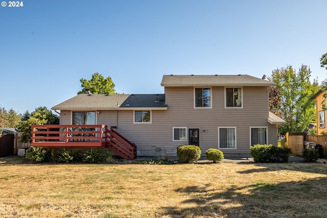 back of house featuring a lawn and a deck