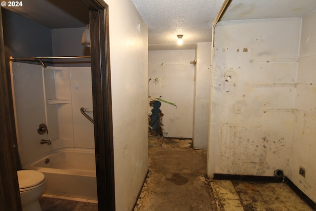 bathroom with a textured ceiling, toilet, concrete flooring, and tub / shower combination