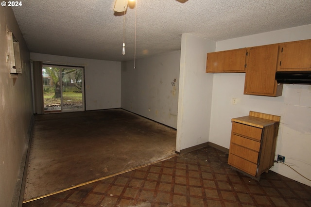 interior space with a textured ceiling and ceiling fan