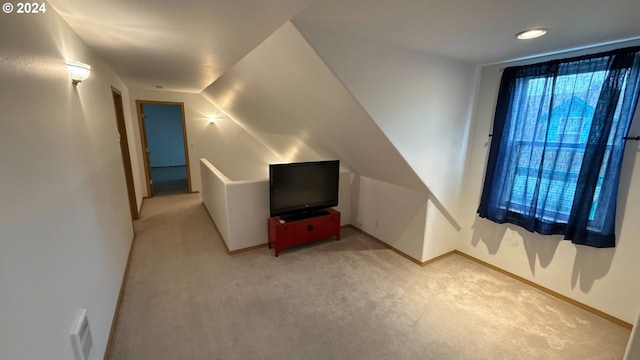 additional living space with light colored carpet and lofted ceiling