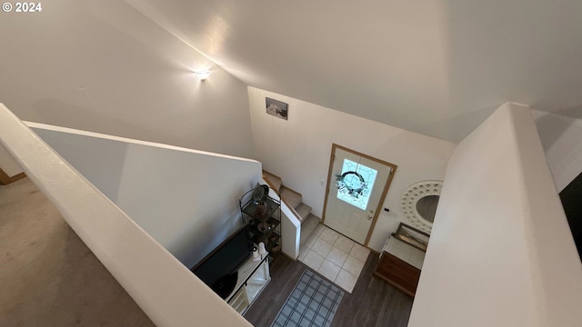 staircase featuring tile patterned floors and lofted ceiling