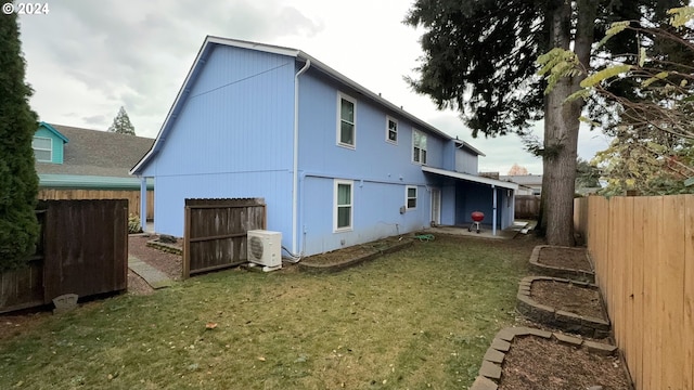 rear view of property with a yard and ac unit