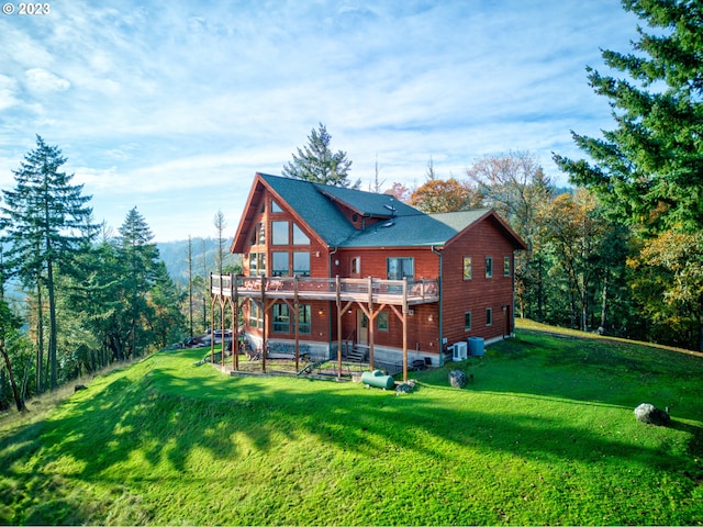 rear view of house with a deck, a yard, and a patio