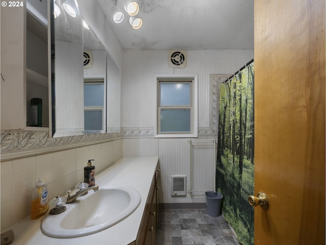 bathroom featuring vanity, tile walls, and walk in shower