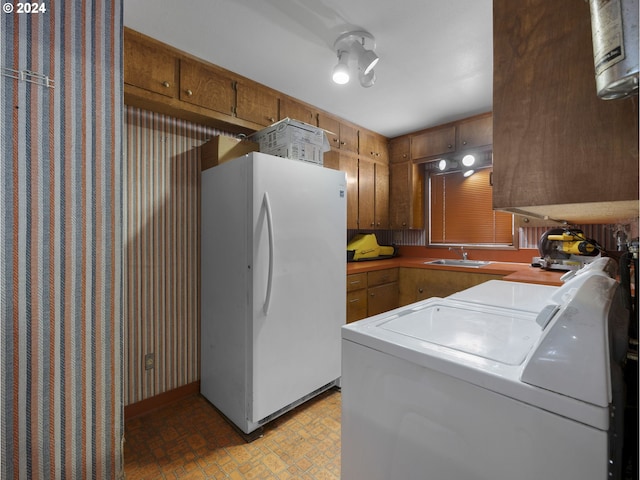 laundry area with separate washer and dryer and sink