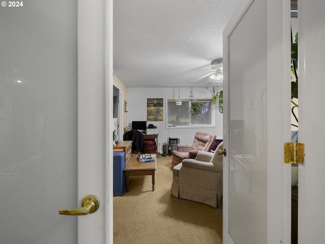 carpeted living room with ceiling fan and a textured ceiling