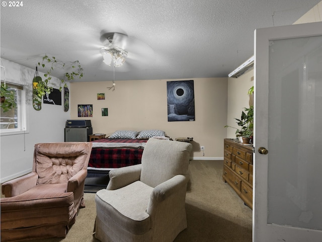 carpeted bedroom featuring ceiling fan and a textured ceiling