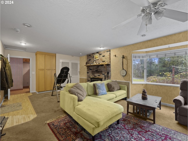 carpeted living room with a textured ceiling, a brick fireplace, and ceiling fan