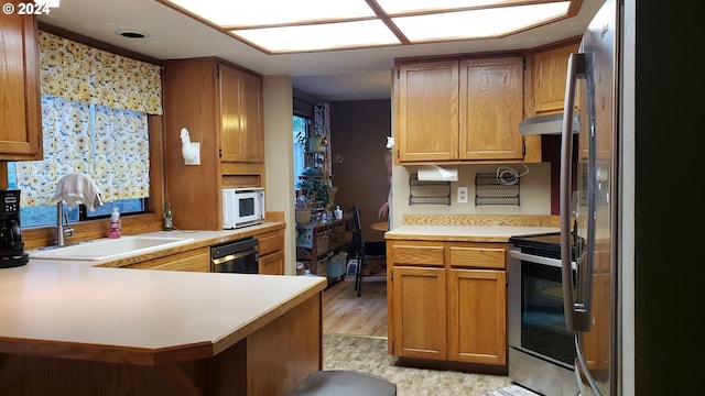 kitchen with sink, stainless steel appliances, and kitchen peninsula