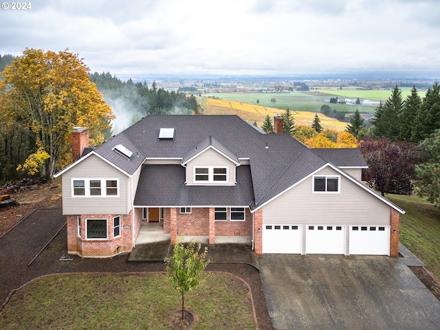 view of front of property with a front yard, a rural view, and a garage