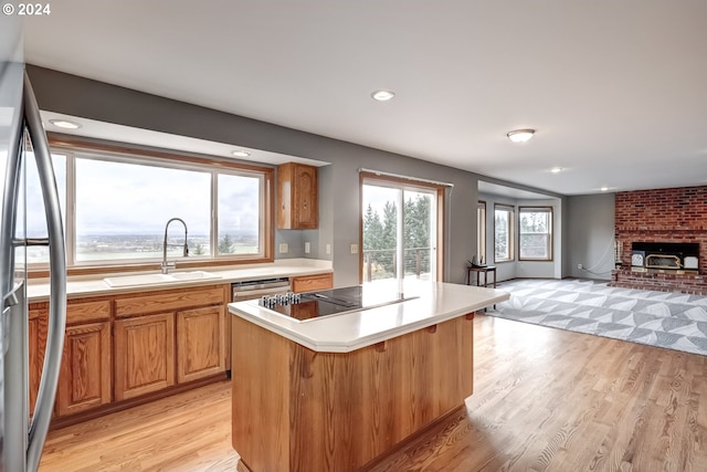 kitchen featuring sink, a kitchen breakfast bar, light wood-type flooring, a kitchen island, and appliances with stainless steel finishes