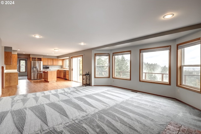 unfurnished living room with light colored carpet