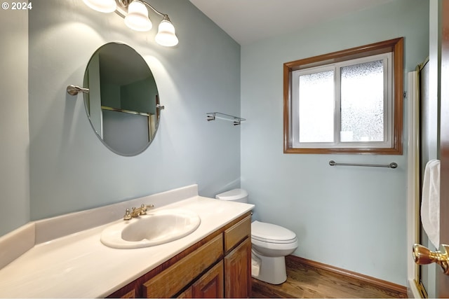 bathroom with toilet, an enclosed shower, wood-type flooring, and vanity