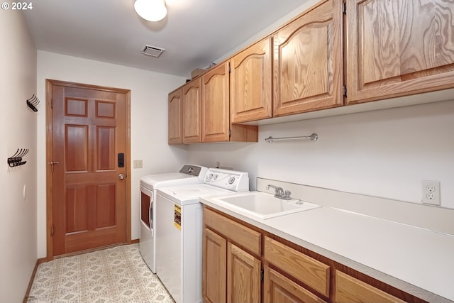 laundry room with sink, cabinets, and washing machine and clothes dryer