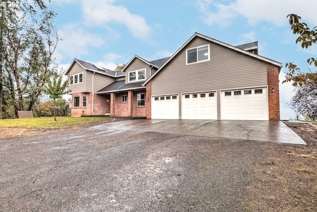 front facade with a front yard, a garage, and solar panels