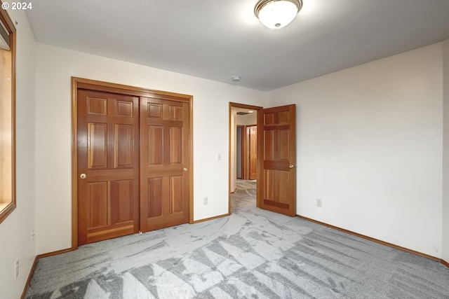 unfurnished bedroom featuring a closet and light carpet