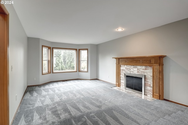 unfurnished living room featuring a fireplace and light carpet