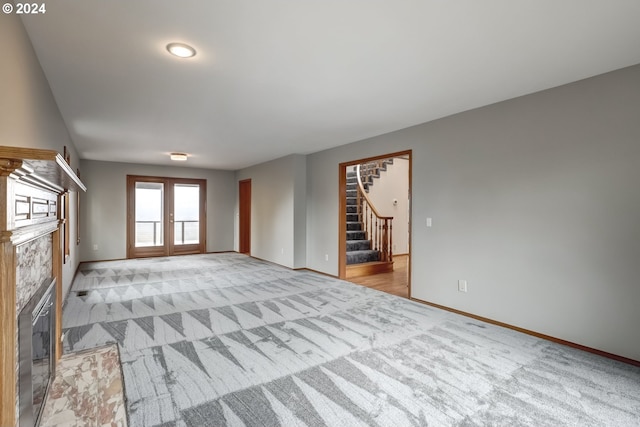 unfurnished living room with light colored carpet and french doors