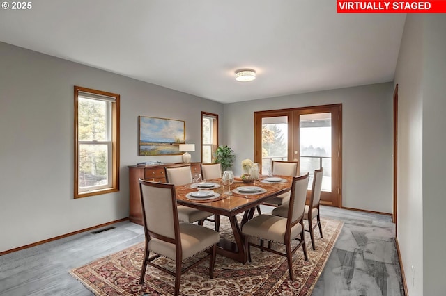 carpeted dining area featuring french doors and plenty of natural light