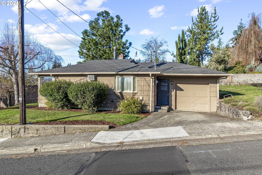 single story home featuring a garage and a front yard