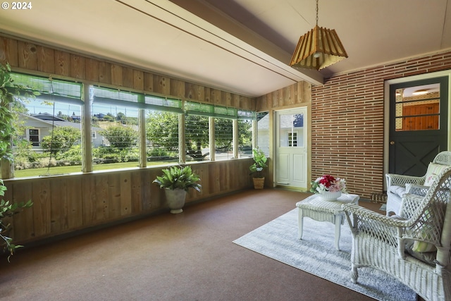 sunroom / solarium featuring vaulted ceiling with beams and a healthy amount of sunlight