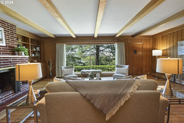 living room with beamed ceiling, hardwood / wood-style floors, a fireplace, and wood walls