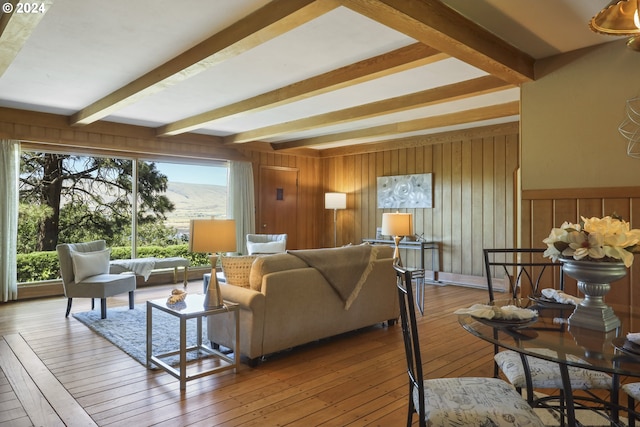 living room featuring hardwood / wood-style floors, wooden walls, and beam ceiling