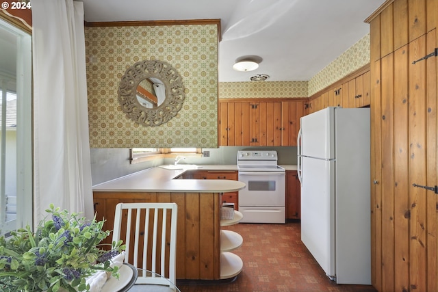 kitchen featuring white appliances, kitchen peninsula, and ornamental molding