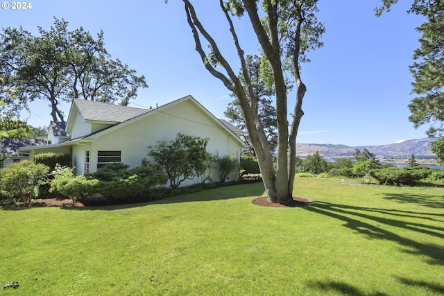 view of home's exterior featuring a mountain view and a lawn