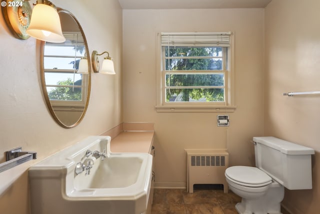 bathroom with a wealth of natural light, toilet, sink, and radiator