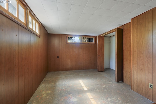 basement with wood walls and a healthy amount of sunlight