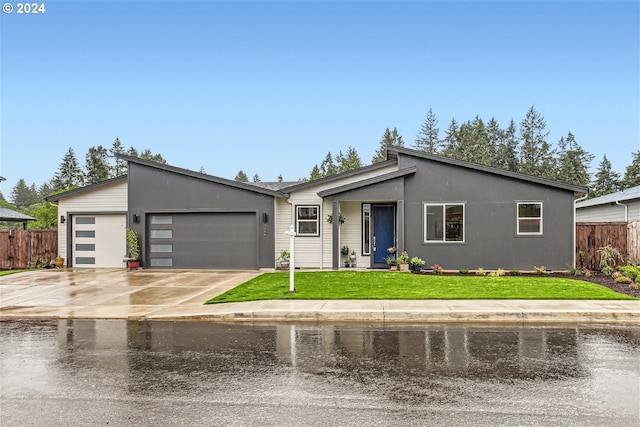 ranch-style home with a garage and a front lawn