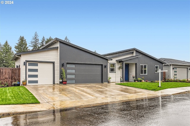 ranch-style home featuring a garage and a front lawn