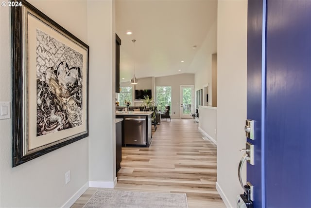 hall featuring vaulted ceiling and light hardwood / wood-style flooring