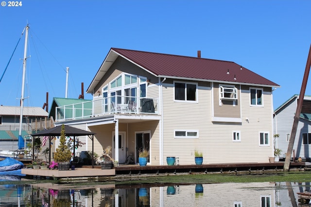 back of house featuring a balcony, a water view, and a patio area