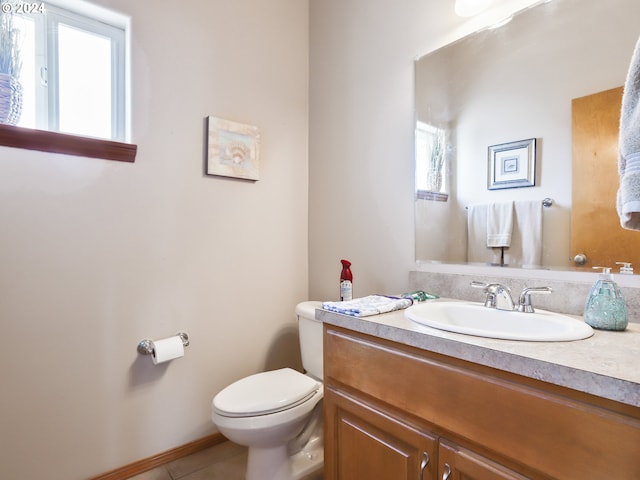 bathroom featuring vanity, tile patterned floors, toilet, and a wealth of natural light