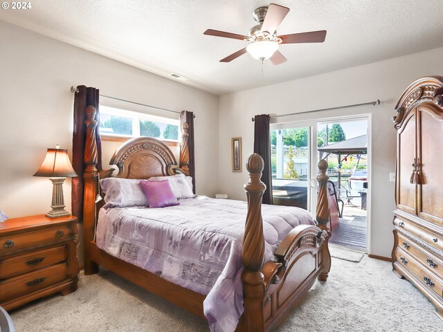 carpeted bedroom featuring multiple windows, a textured ceiling, ceiling fan, and access to exterior