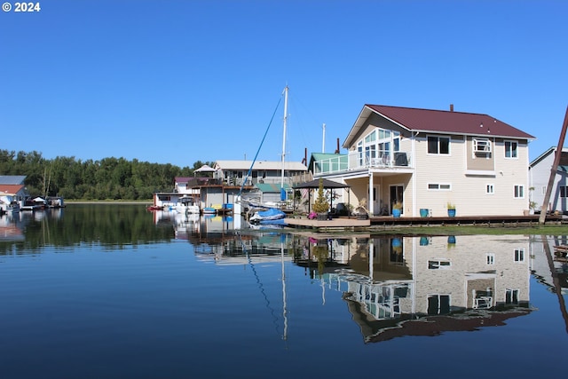 view of dock with a balcony and a water view